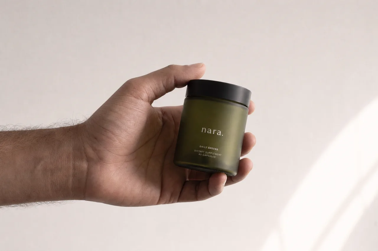Mão segurando o pote verde-oliva da Fórmula Diária